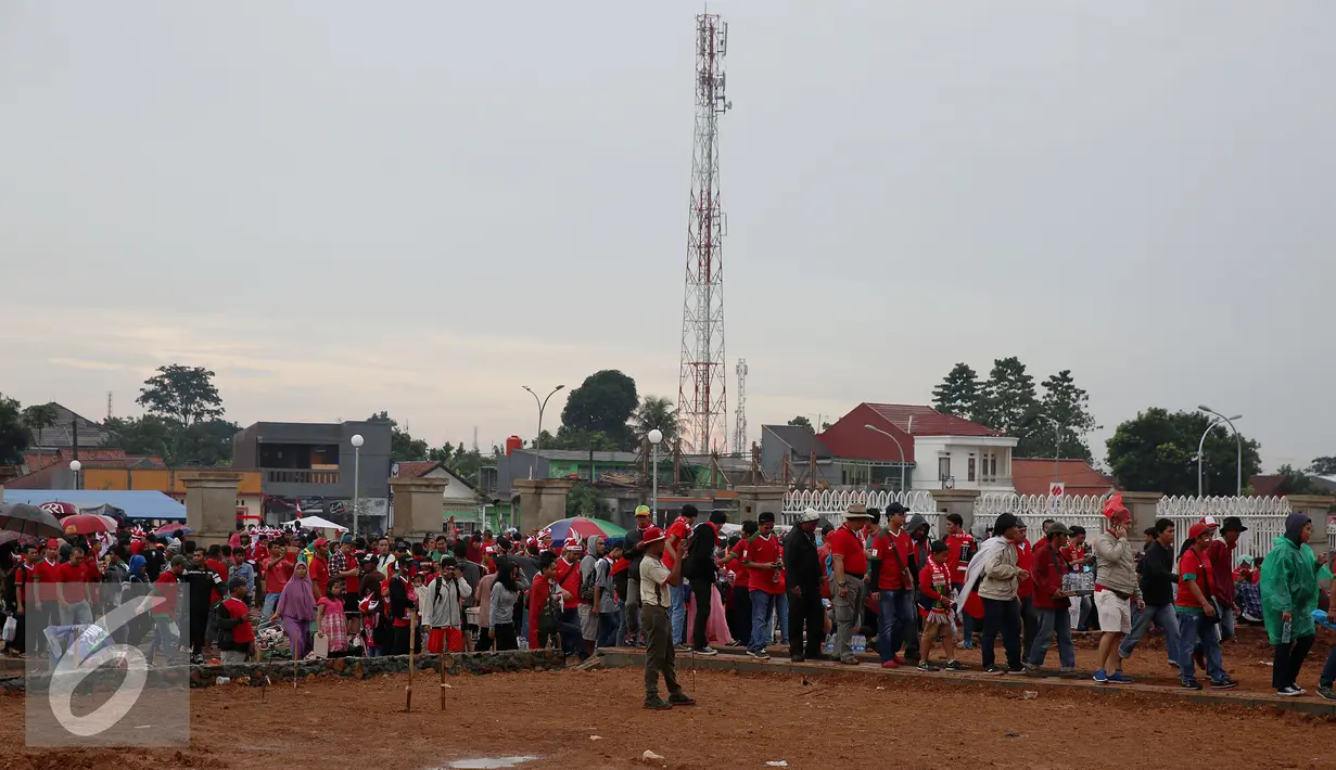 Sejumlah orang memadati Stadion Pakansari untuk menonton final leg pertama Piala AFF 2016, Bogor, Rabu (14/12). Walau di guyur hujan, pendukung tetap datang untuk menyaksikan Tim Nasional Indonesia bertanding. (Liputan6.com/Johan Tallo)