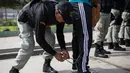 Penjaga membuka belenggu dari anggota tim sepak bola narapidana sebelum bermain di Penjara San Juan de Lurigancho, Lima, Peru, Kamis (24/5). (AP Photo/Rodrigo Abd)