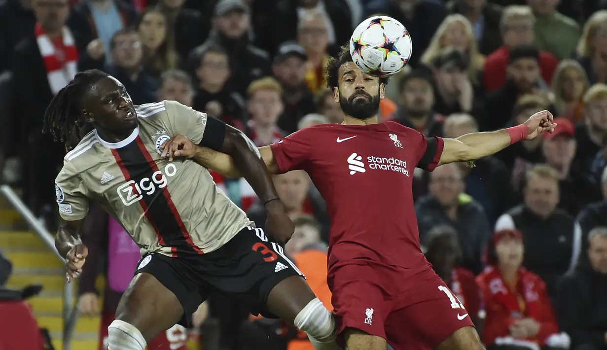 Bek Ajax Amsterdam Calvin Bassey berebut bola dengan penyerang Liverpool Mohamed Salah pada pertandingan kedua Grup A Liga Champions 2022/2023 di Stadion Anfield, Rabu (14/9/2022) dini hari WIB. Liverpool menang susah payah saat menjamu Ajax berkat gol menit akhir bek Joel Matip. (AP Photo/Rui Vieira)