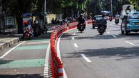 Kendaraan melintasi "stick cone" pembatas jalur sepeda di kawasan Pejompongan, Jakarta, Selasa (29/11/2022). Pemprov DKI Jakarta kembali mengganggarkan dana untuk perawatan jalur dan evaluasi pembatas sepeda pada rancangan APBD tahun anggaran 2023 sebesar Rp7,5 miliar setelah sebelumnya sempat dicoret dari anggaran dan menuai kecaman dari sejumlah pihak. (Liputan6.com/Johan Tallo)