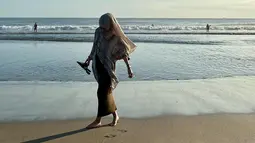 Istri Egy Maulana Vikri begitu menikmati suasana pantai. Ia terlihat senang bisa menginjak pasir pantai dengan kaki telanjang. Foto ini pun banjir like dari warganet. (Liputan6.com/IG/adiba.knza)