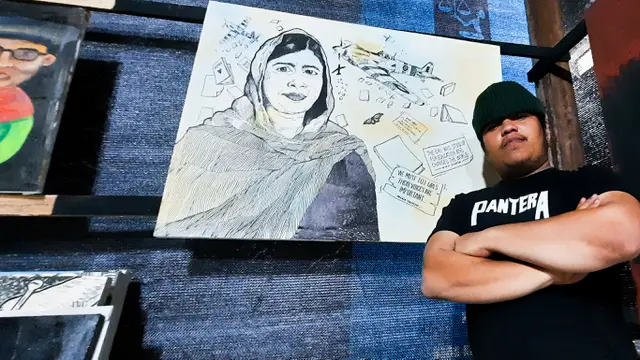 Zaky alias Jack (26), salah seorang seniman drawing berfoto di depan hasil karyanya. Foto diambil pada 15 Desember 2021 (Liputan6.com/Rino Abonita)