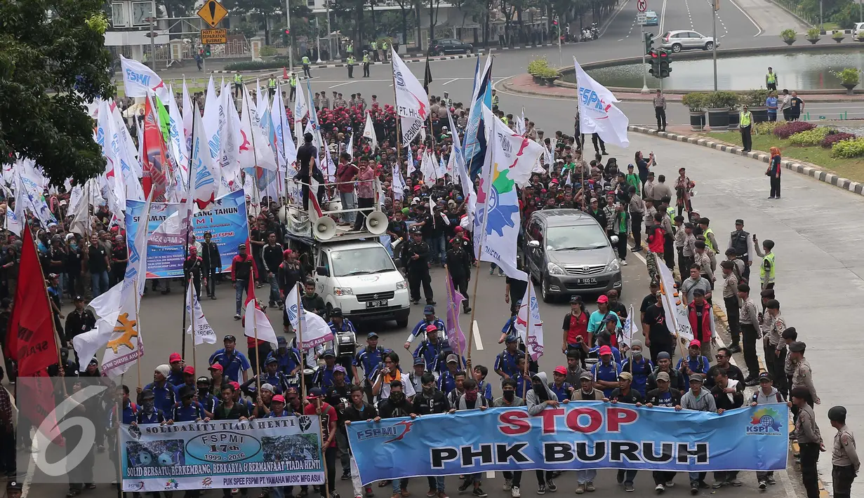Ribuan buruh melakukan longmarch membawa spanduk menuju Istana Merdeka, Jakarta, Sabtu (6/2/2016). Dalam aksi tersebut mereka meminta agar tidak terjadi PHK secara besar-besaran. (Liputan6.com/Angga Yuniar)