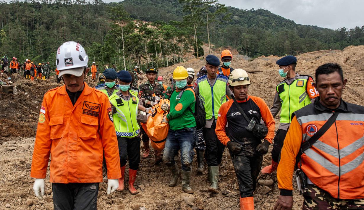 Penemuan ini menambah total korban jiwa menjadi tiga orang. Tampak dalam foto, petugas penyelamat membawa kantong jenazah dari puing-puing rumah yang hancur di lokasi longsor di Desa Situkung, Banjarnegara, Jawa Tengah, pada Rabu 19 November 2025. (DEVI RAHMAN/AFP)
