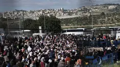 Warga Palestina mengantre bus setelah menyeberang dari Kota Bethlehem di Tepi Barat ke Yerusalem untuk mengikuti sholat Jumat di Kompleks Masjid Al Aqsa selama bulan suci Ramadhan, Jumat (31/3/2023). (AP Photo/Mahmoud Illean)