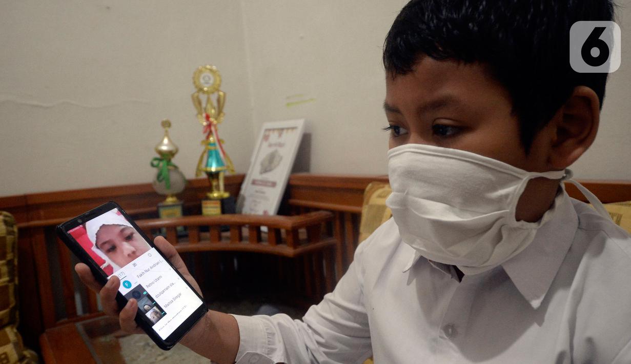 Faqih Nur Andrian, Kelas 2 SDIT As Salamah mengikuti pembelajaran online hari pertama masuk ajaran baru 2020/2021 di rumah di kawasan Pondok Benda, Pamulang, Tangerang Selatan, Banten, Senin (13/7/2020). (merdeka.com/Dwi Narwoko)
