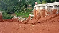 Turap beton sepanjang 15 meter milik Perumahan GDC Cluster Catleya Kelurahan Kalibaru, Kecamatan Cilodong, yang jebol akibat hujan lebat, Sabtu (24/10/2020) malam. (Liputan6.com/George Genesis)