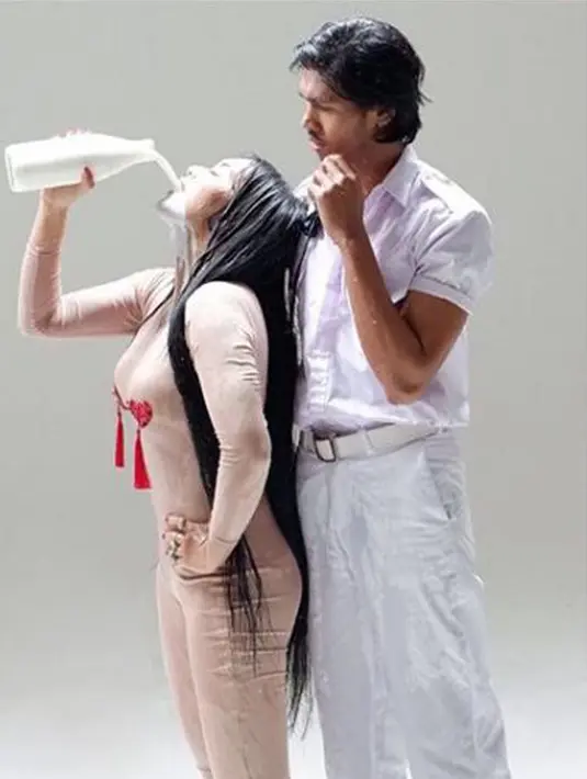 Penyanyi Denada meminum air susu di samping seorang pria di video klip terbarunya. Setelah dirilis, video single terbarunya yang bertajuk "Mutha Futha" itu langsung menyita perhatian netizen. (Instagram/@denadaindonesia)