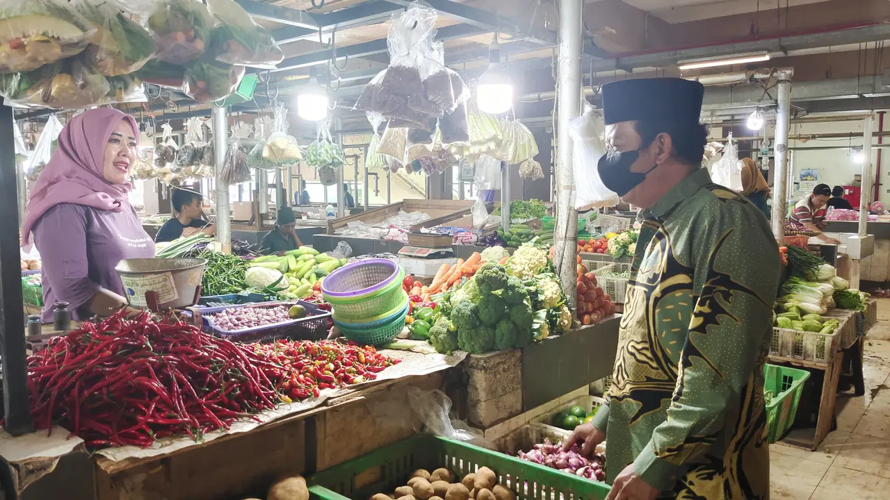 Kepala UPT Pasar Cisalak, Muhammad Sahal meninjau harga kebutuhan pokok di sejumlah pedagang. (Liputan6.com/Dicky Agung Prihanto)