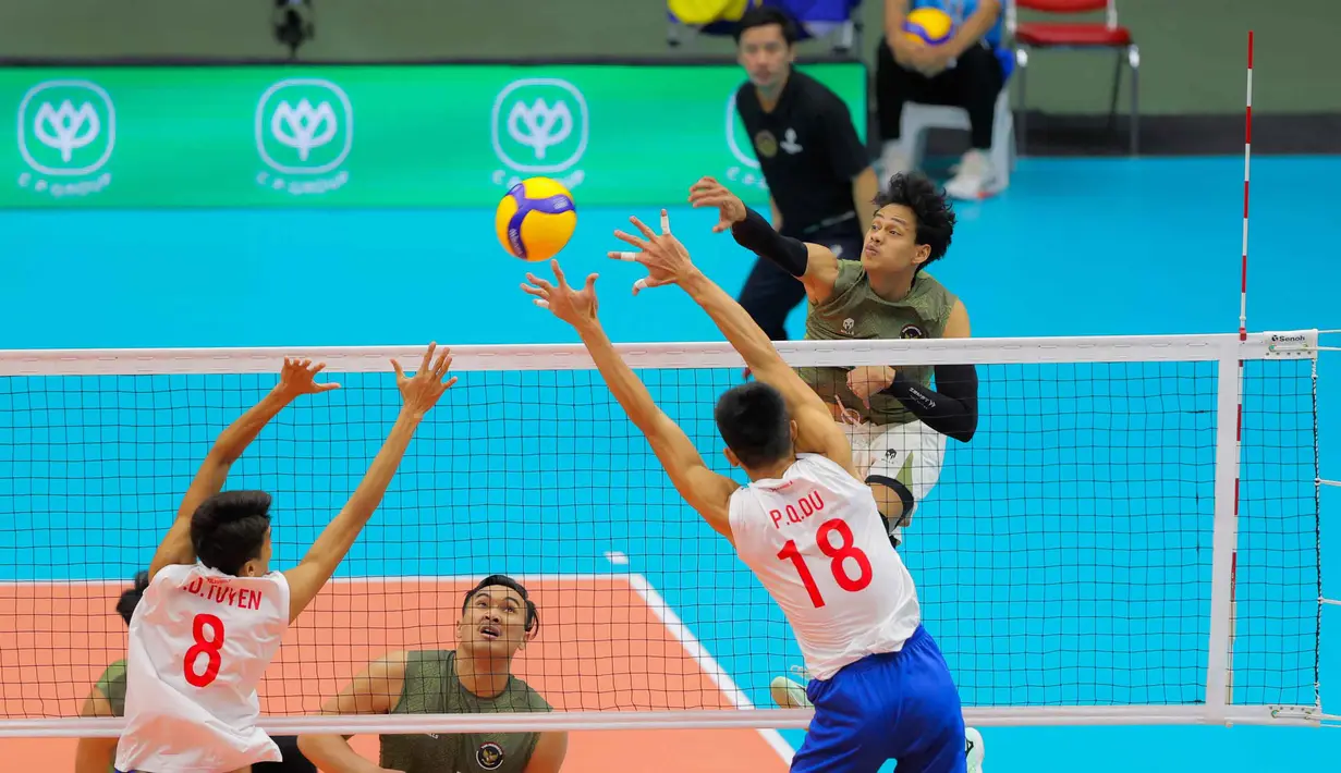 Pertandingan berlangsung sengit sejak awal set pertama. Kedua tim saling bertukar poin. Tampak dalam foto, pemain voli putra Indonesia, Boy Arnez Arabi (kanan) melakukan smash saat melawan Vietnam di babak semifinal SEA Games 2025 di Indoor Stadium Huamark, Bangkok, Thailand, Kamis (18/12/2025). (Bola.com/Bagaskara Lazuardi)