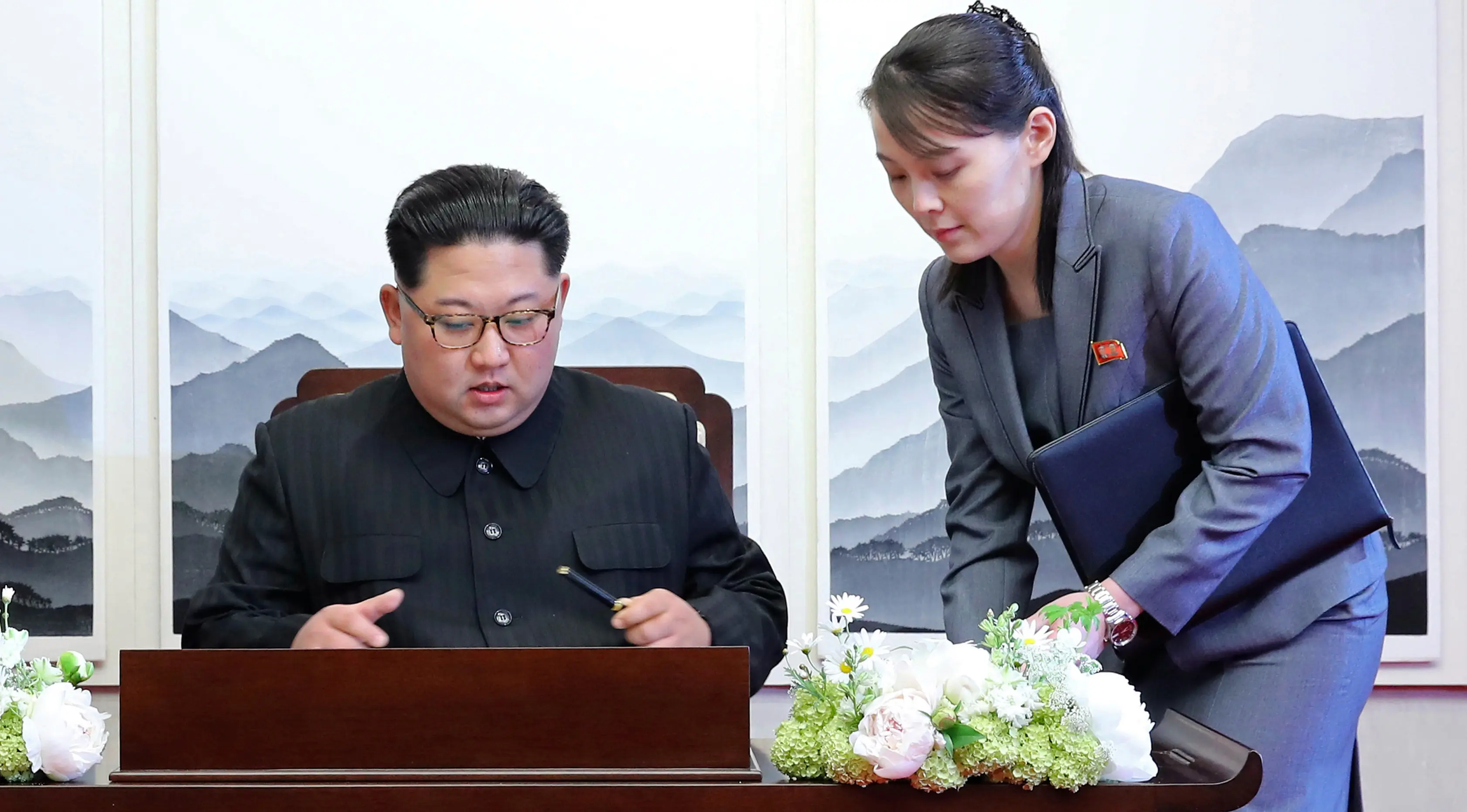 Pemimpin Korea Utara, Kim Jong-un menandatangani buku tamu di Peace House Panmunjom di samping adiknya, Kim Yo Jong sebelum melakukan pertemuan bersejarah dengan Presiden Korea Selatan, Moon Jae-in, Jumat (2/4). (Korea Summit Press Pool via AP)