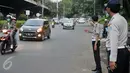 Petugas Dishub mengatur kendaraan yang melintasi Jalan TB Simatupang, Jakarta, Senin (12/12). Dinhubtrans Jaksel menyiagakan petugas di sejumlah titik rawan kemacetan untuk antisipasi penumpukan kendaraan saat arus balik. (Liputan6.com/Yoppy renato)