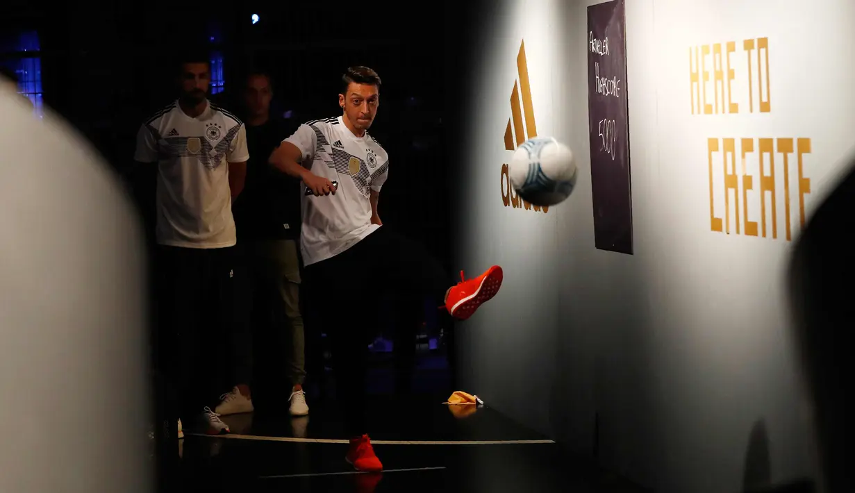 Gelandang Jerman Mezut Ozil menendang bola selama perkenalan jersey terbaru timnas Jerman untuk Piala Dunia 2018 di Berlin (7/11). Jersey ini terinspirasi dari kostum yang pernah dikenakan pada Piala Dunia 1990. (AFP Photo/Ganjil Andersen)