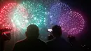 Penonton menyaksikan pertunjukan kembang api dari salah satu peserta dalam puncak kompetisi Pyromusical Internasional ke-9 di Filipina, Sabtu (24/3). Peserta kompetisi adalah para maestro kembang api kelas dunia dari berbagai negara. (AP/Bullit Marquez)