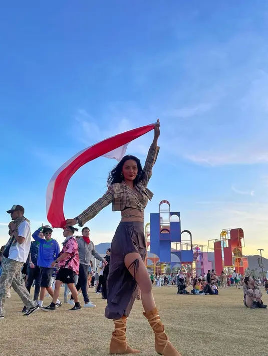 <p>Erika Carlina tak kalah stunning dengan crop top dan celana asimetrisnya. Aktris dan model cantik ini bahkan mengibarkan bendera merah putih saat berfoto. (Instagram/ericarl).</p>