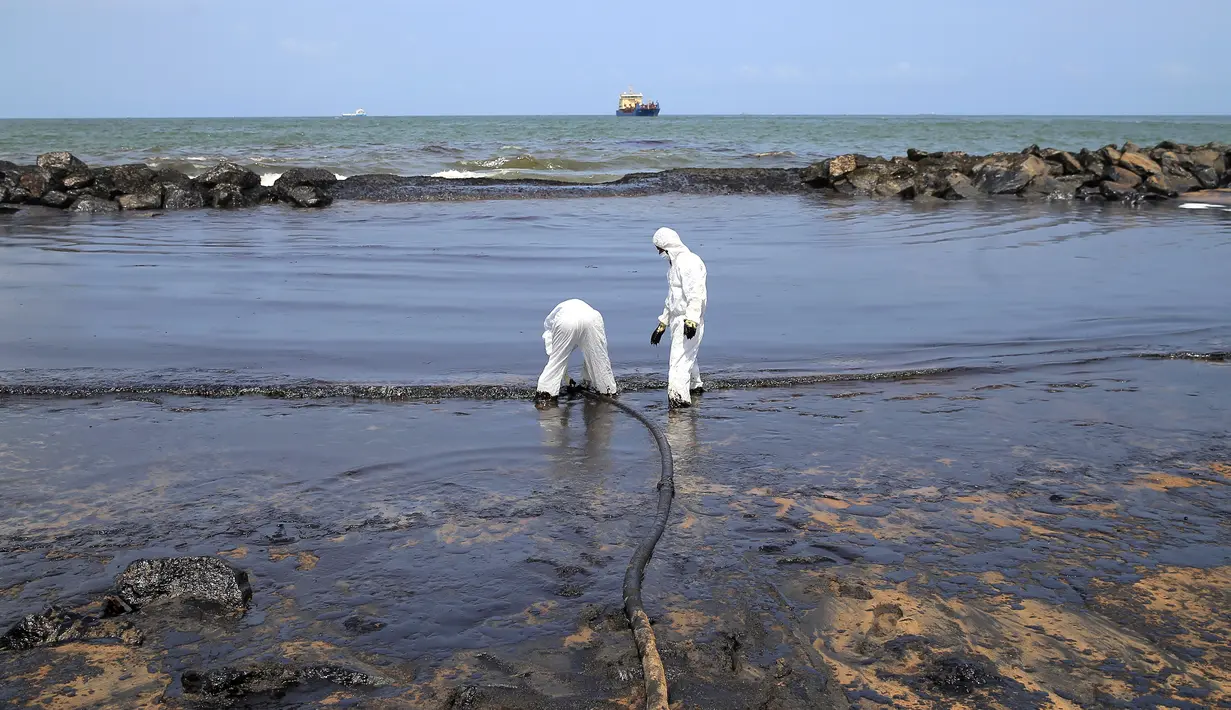 Penjaga pantai Sri Lanka membersihkan tumpahan minyak di sebuah pantai di Uswetakeiyawa, Kolombo, Senin (10/9). Tumpahan minyak mencemari hamparan pantai sekitar 2 kilometer.  (AP Photo/Eranga Jayawardena)