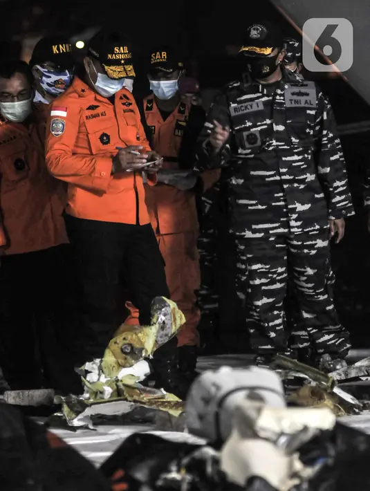 SAR Mission Coordinator (SMC) sekaligus Direktur Operasi Basarnas Brigjen TNI Marsekal Rasman (kiri) mendata menyampaikan keterangan saat serpihan pesawat Sriwijaya Air SJ 182 tiba di Dermaga JICT 2, Tanjung Priok, Jakarta, Minggu (10/1/2021). (merdeka.com/Iqbal S. Nugroho)