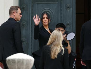 Pesohor asal Amerika Serikat (AS), Kim Kardashian (tengah) melambaikan tangan saat tiba di Pengadilan Assize, Paris, Prancis pada 13 Mei 2025. (Alain JOCARD/AFP)