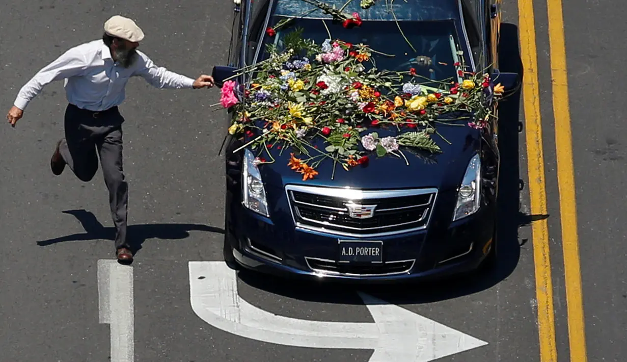 Seorang penggemar berlari mengejar mobil jenazah mantan petinju dunia, Muhammad Ali yang sedang menuju pemakaman di Louisville, Kentucky, Amerika Serikat, Jumat (10/6). (REUTERS / Adrees Latif)