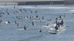 Peselancar menunggu ombak dari pantai Katase-kaigan di Fujisawa, prefektur Kanagawa, dekat Tokyo, Senin (8/6/2020). Jepang mengangkat keadaan darurat coronavirus-nya, mengakhiri pembatasan secara nasional ketika bisnis mulai dibuka kembali. (AP Photo/Koji Sasahara)