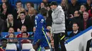 Romelu Lukaku berjalan keluar lapangan melewati Thomas Tuchel dalam pertandingan lanjutan Liga Inggris 2021/2022 antara Chelsea melawan Arsenal di Stamford Bridge 20 April 2022. (AFP/Glyn Kirk)