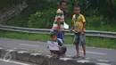 Anak-anak menunggu bus untuk meminta bunyi klakson telolet dari bus yang lewat di jalan raya A Yani Surakarta, Solo, Kamis (22/12). Fenomena ini mendunia setelah beberapa artis dan tokoh terkenal dunia berkomentar di media sosial. (Liputan6.com/Gholib)