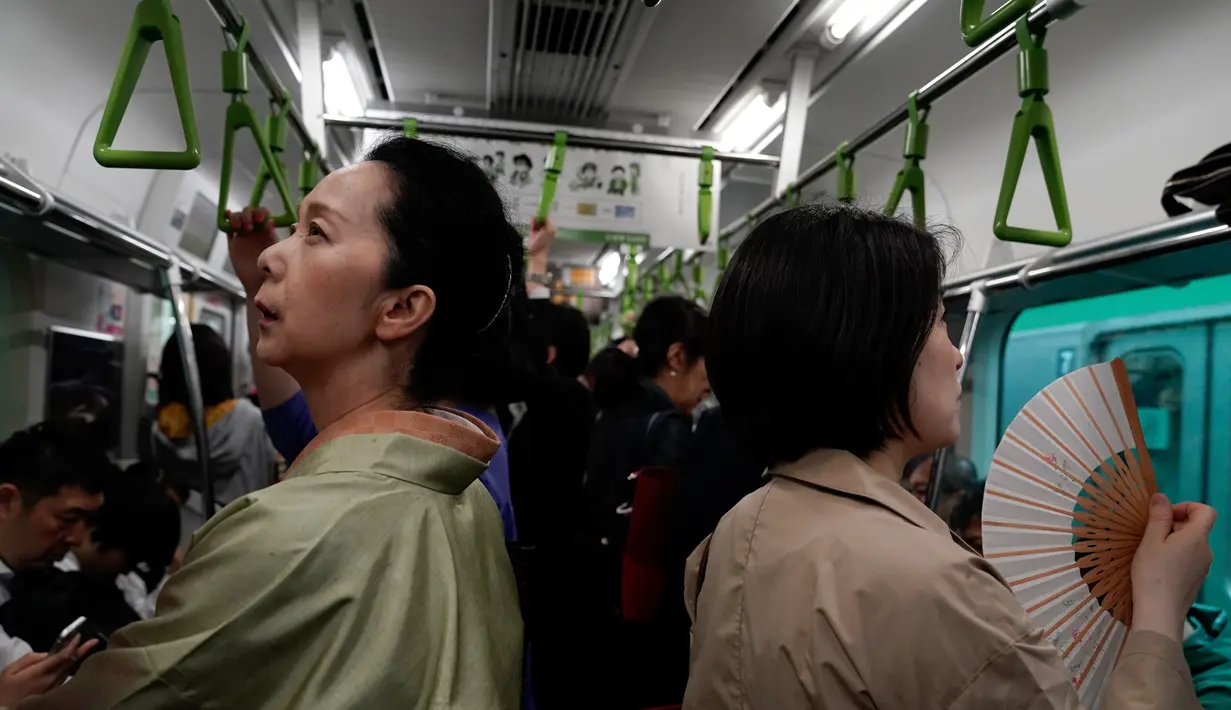 Penumpang wanita berpakaian kimono menaiki kereta Yamanote Line di Tokyo, Jepang, Selasa (21/5/2019). (AP Photo/Jae C. Hong)