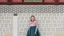 Bagian atasnya berupa jeogori berwarna dusty pink dengan detail pita putih yang terikat manis di sisi kanan, memancarkan kesan feminin sekaligus klasik. [@shandyaulia].