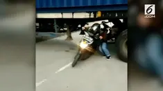 Akibat truk kontainer mogok dan menutupi akses jalan, para pengendara motor ini tak kehabisan akal dan melintas melalui kolong.