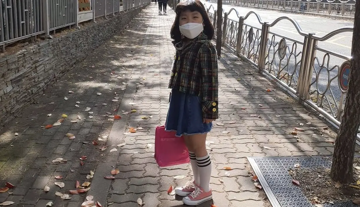 Tak selalu pirang, Go Do Yoen juga memiliki rambut yang hitam dengan gaya poni depannya. Ia tampil cute dengan jaket tartan, dipadukan mini skirt denim. Sneakes model converse dengan kaos kaki panjangnya sangat sesuai dengan gaya pakaian seumurnya. Instagramnya @lee_6038.