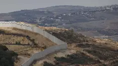 Sebuah foto yang diambil dari Israel memperlihatkan perbatasan yang memisahkan Israel utara dari Lebanon selatan, dengan desa Lebanon Ain Ebel terlihat di latar belakang pada 16 November 2025. Israel membangun tembok perbatasan baru di sepanjang garis perbatasan dengan Lebanon wilayah bagian Selatan. (Jalaa MAREY/AFP)
