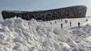 Warga bermain ski di antara lereng salju buatan di sekitar National Olympic Stadium, Tiongkok, Senin (2/1/2012). Meskipun minim salju namun sejumlah negara tetap memilih Beijing sebagai tuan rumah Olimpiade Musim Dingin 2022. (EPA/How Hwee Young)