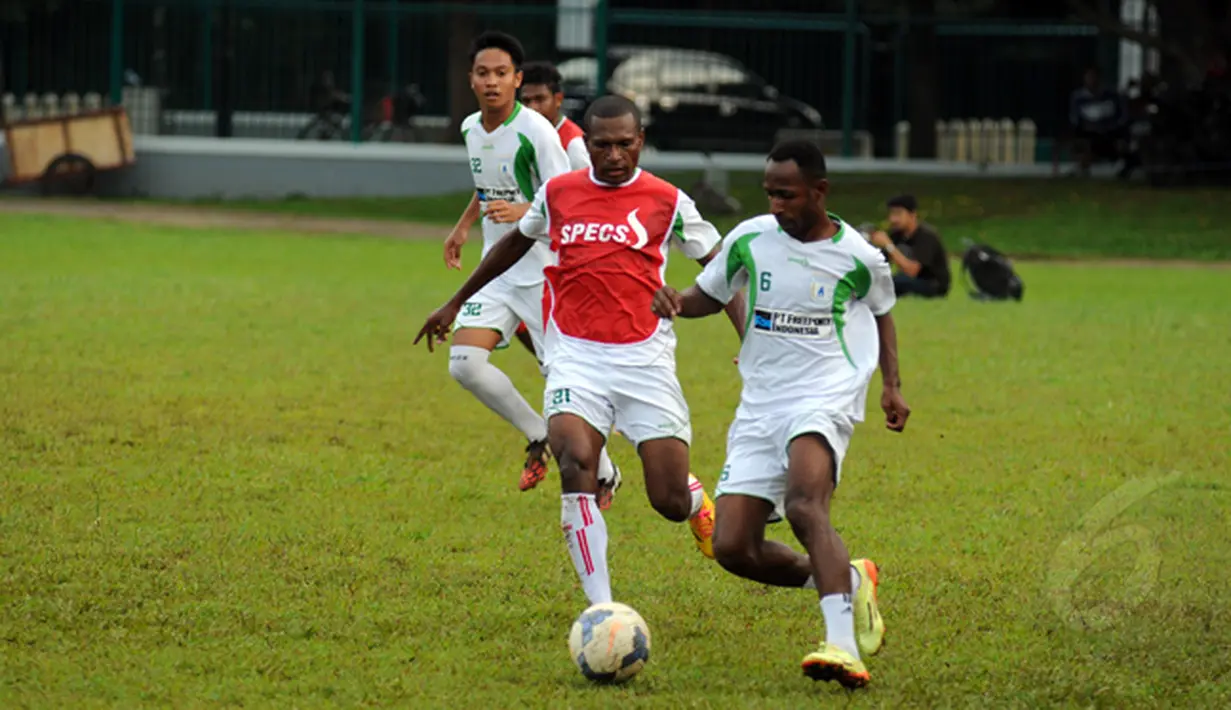 Gelandang Persipura Jayapura, Yustinus Pae (kedua dari kanan) berusaha merebut bola dari Gerard Pangkali saat berlatih di Lapangan C Senayan, Jakarta, Senin (16/2/2015). (Liputan6.com/Helmi Fithriansyah)