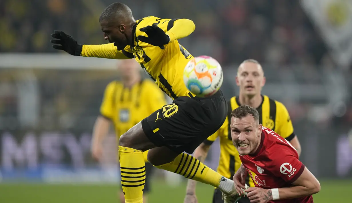 Penyerang Borussia Dortmund, Anthony Modeste berebut bola dengan bek RB Leipzig, David Raum dalam laga pekan ke-23 Bundesliga atau Liga Jerman 2022/2023 di Signal Iduna Park, Sabtu (4/3/2023) dini hari WIB. Kemenangan penting berhasil diamankan Borussia Dortmund saat menjamu RB Leipzig. (AP Photo/Martin Meissner)