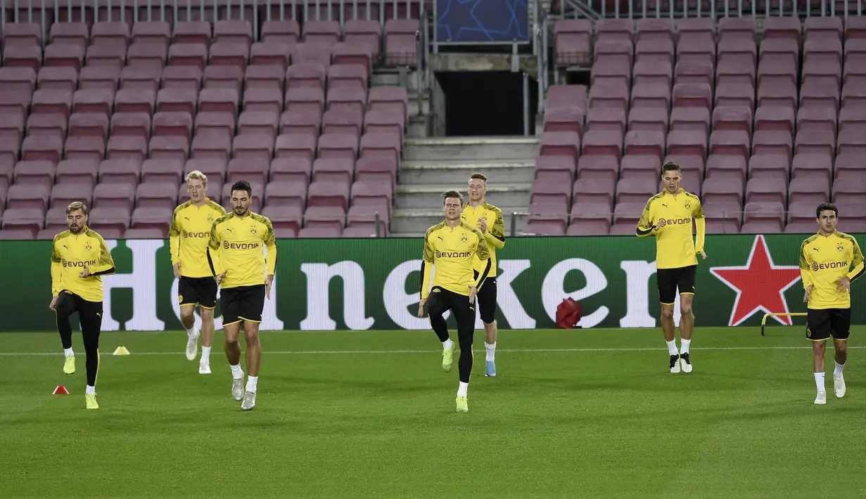 Para pemain Borussia Dortmund melakukan pemanasan saat mengikuti sesi latihan di stadion Camp Nou di Barcelona (26/11/2019). Dortmund akan bertanding melawan Barcelona pada Grup F Liga Champions. (AFP Photo/Josep Lago)