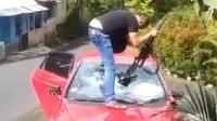 Video seseorang yang diduga polisi merusak mobil berwarna merah menggunakan senjata api laras panjang viral di media sosial. (Liputan6.com/ Ist)