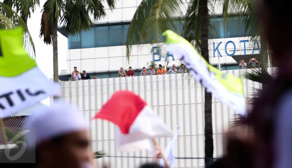 Sejumlah pegawai Balai Kota DKI melihat iringan massa aksi damai 4 November yang melewati kantor mereka, Jakarta, Jumat (4/11). Meski ada demo besar-besaran, pegawai Balai Kota tetap masuk kerja seperti biasa. (Liputan6.com/Faizal Fanani)