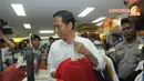 Dengan pengawalan dari petugas polisi, Jokowi tampak memilih beberapa helai kaos (Liputan6.com/Herman Zakharia) 