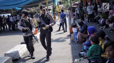 Pasukan Brimob Polda Metro Jaya bersenjata lengkap patroli di Terminal Kampung Rambutan, Jakarta, Selasa (19/6). Penjagaan dilakukan untuk memberi rasa aman kepada pemudik pada arus balik Lebaran 2018. (Liputan6.com/Faizal Fanani)