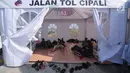 Sejumlah pemudik beristirahat di tenda "rest area alternatif" Km 153 Cipali, Jawa Barat, Rabu (21/6). Untuk melepas lelah, sebagian pemudik berhenti dan beraktivitas di sejumlah area peristirahatan sementara yang tersedia. (Liputan6.com/Gempur M Surya)