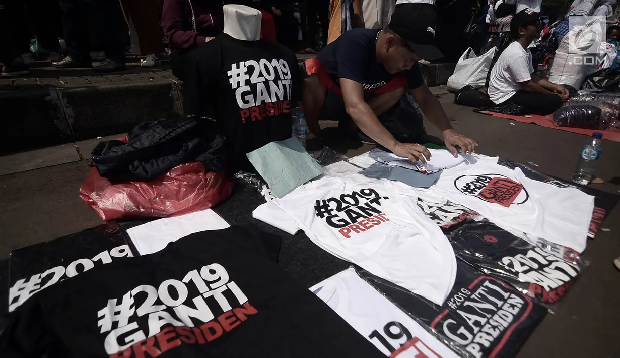 Pedagang kaus #2019GantiPresiden merapikan dagangan saat menggelarnya di sekitar lokasi deklarasi akbar di Monas, Jakarta, Minggu (6/5). (Merdeka.com/Iqbal Nugroho)