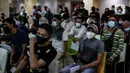 Pedagang antre mengikuti vaksinasi massal di Pasar Tanah Abang, Jakarta, Sabtu (31/7/2021). Menko Marves Luhut Binsar Pandjaitan meminta Kemenkes bersama TNI-Polri terus mempercepat program vaksinasi COVID-19 hingga mencapai dua juta suntikan per hari mulai Agustus 2021. (Liputan6.com/Johan Tallo)