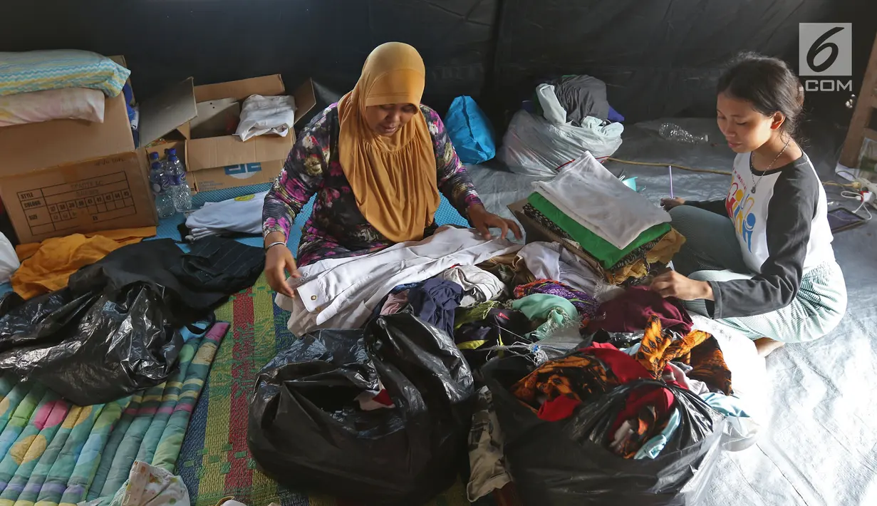 Korban kebakaran memilih bantuan berupa pakaian di posko pengungsian SDN 10/11 Pagi Cipinang Utara, Jakarta, Selasa (20/8/2019). Puluhan warga terdampak kebakaran di Kawasan Prumpung, Jatinegara saat ini masih sangat membutuhkan bantuan seperti alas tidur dan popok bayi. (Liputan6.com/Herman Zakhari
