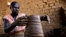 Seorang perajin Sudan membuat tembikar di Khartoum, Sudan (20/10/2020). Para perajin tembikar di Sudan memanfaatkan tanah liat sisa banjir untuk membuat benda-benda kerajinan tersebut. (Xinhua/Mohamed Khidir)