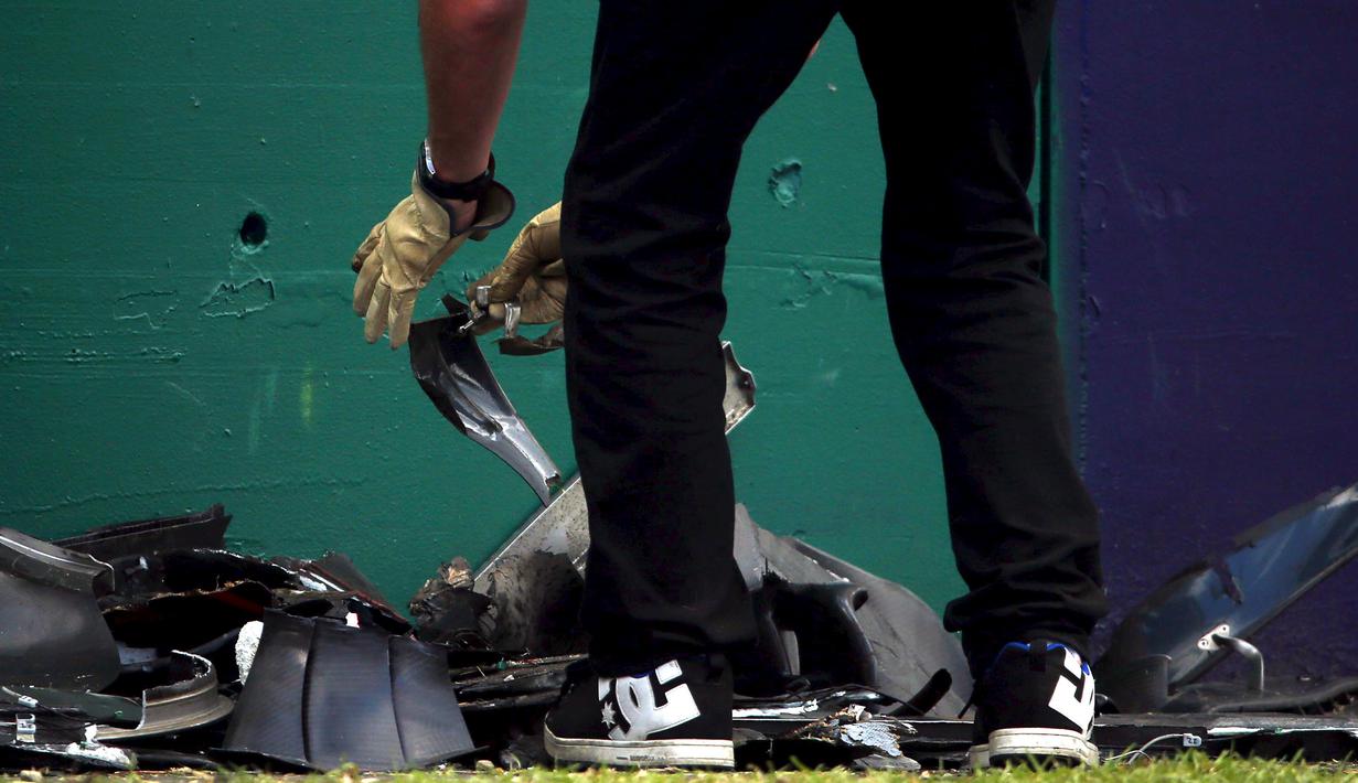 Puing dari mobil balap yang hancur akibat kecelakaan saat pertarungan di lap 17 F1 Grand Prix Australia di Melbourne, Minggu (20/3). Insiden terjadi ketika pembalap McLaren, Fernando Alonso mencoba menyalip dari sisi kiri lintasan. (REUTERS/Joe Castro)