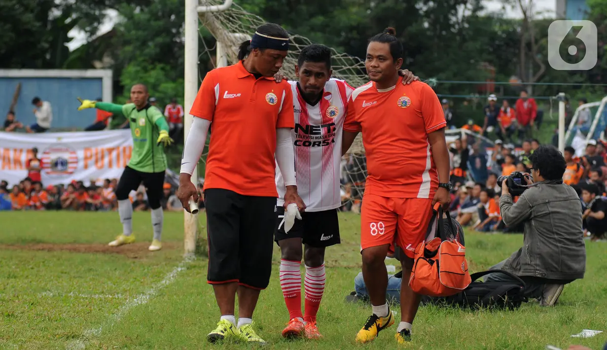 Gelandang Persija Ramdani Lestaluhu (tengah) dibopong keluar akibat cedera saat laga uji coba melawan Barito Putera di Stadion Bea Cukai, Jakarta, Selasa (5/4/2016). (Liputan6.com/Helmi Fithriansyah)