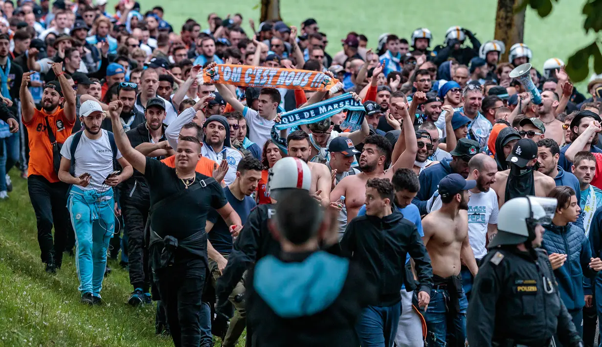 Para pendukung Olympique Marseille dikawal polisi saat menuju Red Bull Arena untuk menonton pertandingan melawan FC Salzburg di Austria (3/5). Pengawalan ini bertujuan untuk menghindari bentrokan antar pendukung. (JFK / EXPA / APA / AFP)