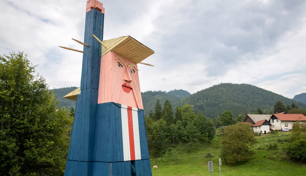 Sebuah patung kayu yang menyerupai Donald Trump didirikan di Sela pri Kamniku, kawasan utara Slovenia, 30 Agustus 2019. Patung Trump setinggi 8 meteritu mengenakan setelan biru, kemeja berwarna putih, dasi merah, serta mengangkat tangan seperti Patung Liberty. (AP/Darko Bandic)