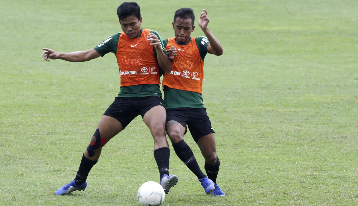 Pemain Timnas Indonesia U-22, Nurhidayat Haris, berebut bola dengan Dallen Doke saat latihan di Stadion Madya Senayan, Jakarta, Kamis (24/1). Latihan ini merupakan persiapan jelang Piala AFF U-22. (Bola.com/Yoppy Renato)
