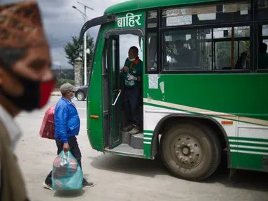 Calon penumpang bersiap naik bus di Kathmandu, Nepal (16/7/2020). Beberapa perusahaan angkutan umum di Lembah Kathmandu sudah mulai mengoperasikan kembali rute mereka untuk pertama kalinya dalam hampir empat bulan setelah menerima persyaratan operasional dari pemerintah. (Xinhua/Sulav Shrestha)
